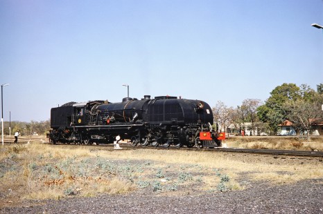 National Railways of Zimbabwe Garratt  steam locomotive no. 608 stands alone on the track in Mbalabala, Matabeleland, Zimbabwe, on August 2 or 3, 1991. Photograph by Fred M. Springer, © 2014, Center for Railroad Photography and Art. Springer-Hedjaz-ZimZam(1)-20-34
