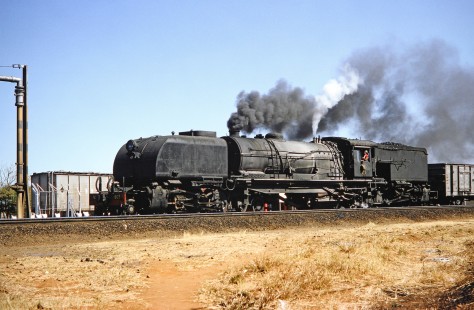 National Railways of Zimbabwe Garratt  steam locomotive with a  freight train in Bulawayo, Zimbabwe, on August 4, 1991. Photograph by Fred M. Springer, © 2014, Center for Railroad Photography and Art. Springer-Hedjaz-ZimZam(1)-21-23