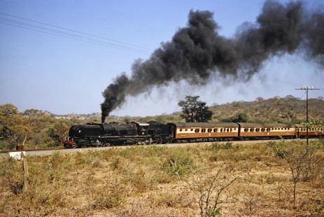 National Railways of Zimbabwe Garratt steam locomotive no. 608 keeps a brisk pace as it rounds a small curve with a passenger train near Bulawayo, Zimbabwe, on August 2, 1991. Photograph by Fred M. Springer, © 2014, Center for Railroad Photography and Art. Springer-Hedjaz-ZimZam(1)-19-02