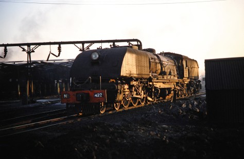 National Railways of Zimbabwe Garratt steam locomotive no. 422 waits in the yard as the last rays of sun cast it in shadow in Bulawayo, Zimbabwe, on August 2, 1991. Photograph by Fred M. Springer, © 2014, Center for Railroad Photography and Art. Springer-Hedjaz-ZimZam(1)-19-31