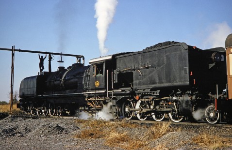 A worker relaxes atop of National Railways of Zimbabwe steam locomotive no. 608 as it takes on water near Bulawayo, Zimbabwe, on August 2, 1991. Photograph by Fred M. Springer, © 2014, Center for Railroad Photography and Art. Springer-Hedjaz-ZimZam(1)-19-12