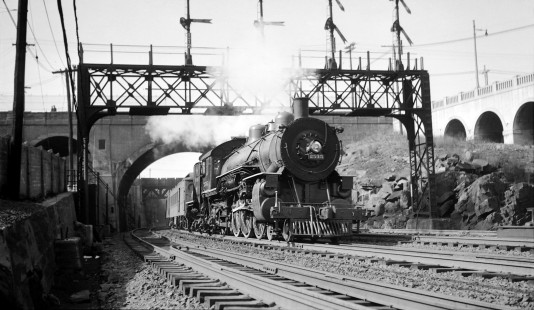 Eastbound Erie Railroad (ERIE) 4-6-2 steam locomotive #2535 in Jersey City, New Jersey at the east end of the Bergen Arches, circa 1940. Palisade Avenue is visible on bridge above tracks. The structure to the right is the ramp to the upper level of New Jersey Route 139. Structer at left and the the bridge in the distance was a PSCT/PSNJ trolley line. Photograph by Robert A. Hadley. Hadley-03-070-02 © 2016, Center for Railroad Photography and Art