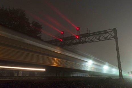 Amtrak passenger train no. 14, the northbound <i>Coast Starlight</i>, passes under a searchlight signal bridge as it departs Davis, California, on the night of February 18, 2015.

Read more about the <a href="http://www.railphoto-art.org/awards/2017-awards/" rel="nofollow">2017 John E. Gruber Creative Photography Awards Program</a>.