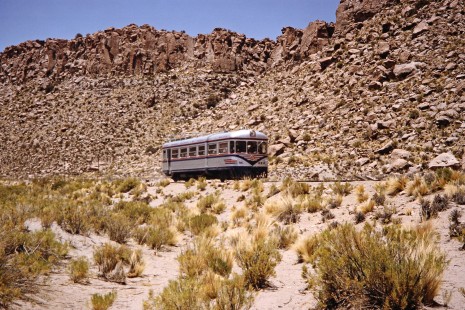Empresa Nacional de Ferrocarriles Bolivia railcar no. M323 almost blends into the rocky landscape of the Bolivian Plateau nearby the Mauri River, Pedro Domingo Murillo, Bolivia, as it travels toward Chile, on October 2, 1992. Photograph by Fred M. Springer, © 2014, Center for Railroad Photography and Art. Springer-ARG-PA-CHI-BO2-15-25