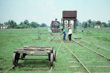 Two workers tend to the tracks as Ferrocarril Presidente Carlos Antonio López (later Ferrocarriles del Paraguay SA FEPASA) steam locomotive no. 151 waits in Carmen del Paraná, Itapúa, Paraguay, on October 23, 1990. Photograph by Fred M. Springer, © 2014, Center for Railroad Photography and Art. Springer-SOAM1-24-27