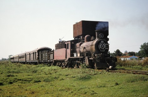 Ferrocarril Presidente Carlos Antonio López (later Ferrocarriles del Paraguay SA FEPASA) steam locomotive no. 59 pauses as several workers attend its wood fuel supply in Carmen del Paraná, Itapúa, Paraguay, on October 21, 1991. Photograph by Fred M. Springer, © 2014, Center for Railroad Photography and Art. Springer-ARG-PA-CHI-BO2-04-26