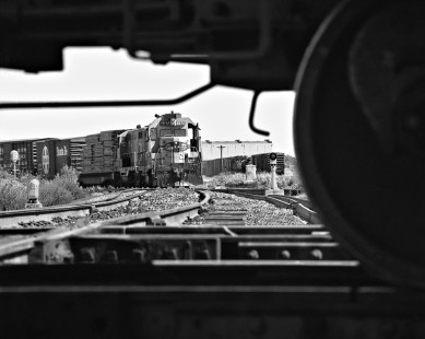 Framed by Missouri Pacific Railroad freight train at Tower 55 (Fort Worth, Texas), Atchison, Topeka and Santa Fe Railway switcher crew assembles local train at nearby yard in May 1974. Photograph by J. Parker Lamb, © 2016, Center for Railroad Photography and Art. Lamb-02-070-04