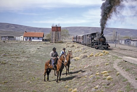 Two men on horseback greet Viejo Expreso Patagónico (Old Patagonian Express) steam locomotive no. 19 as it arrives at the remote station of Fitalancao, near the halfway point of the 250-mile line, on October 29, 1995. Photograph by Fred M. Springer.          © 2014, Center for Railroad Photography and Art; Springer-CHI-ARG1-09-13