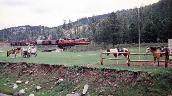 Chicago, Burlington and Quincy Railroad SD9s locomotives nos. 362 and 337 leading a freight train out of Hill City, South Dakota, and past horses on June 10, 1968. Photograph by Thomas F. McIlwraith, McIlwraith-01-017-09, © 2018, Center for Railroad Photography & Art, <a href="http://www.railphoto-art.org" rel="nofollow">www.railphoto-art.org</a>