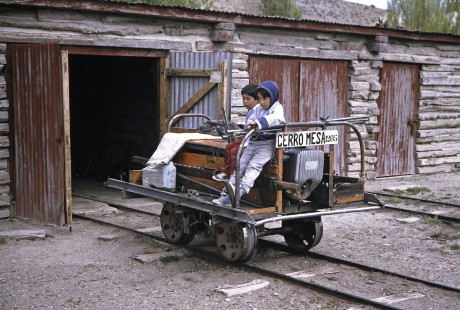 A couple of children pose on narrow gauge maintenance section car in Ñorquinco, Chubut, Argentina, on October 31, 1995. © 2014, Center for Railroad Photography and Art, Photograph by Fred M. Springer. Springer-CHI-ARG1-12-15