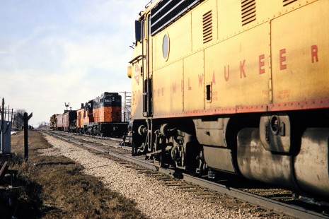 Milwaukee Road locomotive no. 100C passing a work train led by GP9 no. 266 at Ixonia, Wisconsin, on Saturday, March 18, 1967. Photograph by Thomas F. McIlwraith, McIlwraith-01-007-15, © 2018, Center for Railroad Photography & Art, <a href="http://www.railphoto-art.org" rel="noreferrer nofollow">www.railphoto-art.org</a>