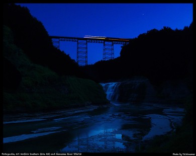 Norfolk Southern freight train crossing the Genessee River at Portageville, New York, during the "blue hour" of July 26, 2013. The photographed combined two exposures, made just moments apart, one optimized for the scene and another for the streaks of light, to achieve the final image.
