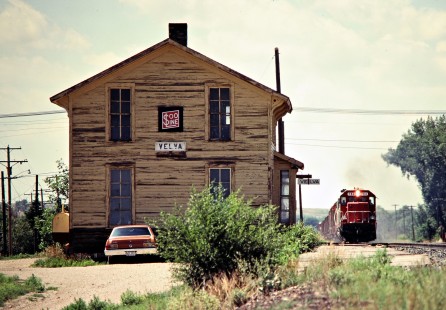 Eastbound Soo Line Railroad freight train passing station at Velva, North Dakota, on July 6, 1980. Photograph by John F. Bjorklund, © 2016, Center for Railroad Photography and Art. Bjorklund-83-08-07