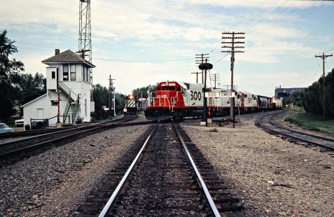 Westbound Soo Line Railroad freight train crosses in front of a westbound Burlington Northern train at Soo Tower in Minot, North Dakota, on July 5, 1980. Photograph by John F. Bjorklund, © 2016, Center for Railroad Photography and Art. Bjorklund-83-05-17