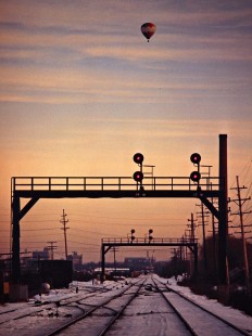Grand Trunk Western Railroad track and signals with hot air balloon near Pontiac, Michigan, in February 1981. Photograph by John F. Bjorklund, © 2016, Center for Railroad Photography and Art. Bjorklund-58-28-14