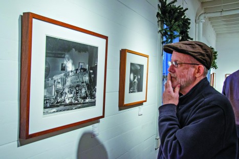 Dennis Livesey studies prints in our exhibition "Railroads and the American Industrial Landscape: Ted Rose Paintings and Photographs" at the Valley Railroad's Oliver Jensen Gallery in Essex, Connecticut, on Friday, October 28. Photograph by Steve Barry