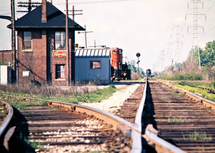 Northbound Detroit, Toledo and Ironton Railroad freight train crossing Penn Central track at Penford Tower in Taylor, Michigan, on May 12, 1973, as a PC train waits in the distance. Photograph by John F. Bjorklund, © 2016, Center for Railroad Photography and Art. Bjorklund-50-07-11