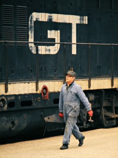 Grand Trunk Western Railroad crewman walking past commuter locomotive at Brush Street Station in Detroit, Michigan, on April 20, 1973. Photograph by John F. Bjorklund, © 2016, Center for Railroad Photography and Art. Bjorklund-58-14-14