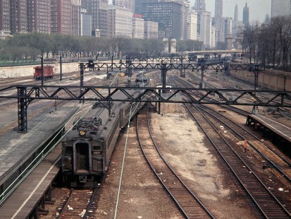 Illinois Central Railroad electric suburban train approaching footbridge at Central Station in Chicago, Illinois, with Michigan Boulevard buildings in background, April 1967. Photograph by John F. Bjorklund, © 2016, Center for Railroad Photography and Art. Bjorklund-60-01-15