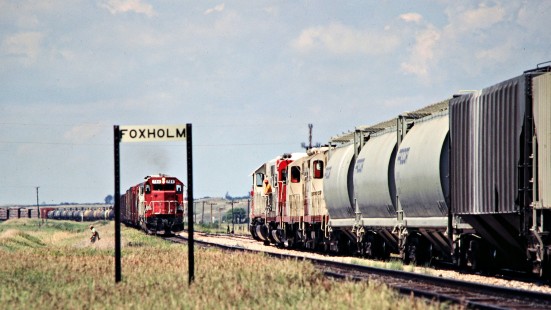 Westbound and eastbound Soo Line Railroad freight trains meet at Foxholm, North Dakota, on July 6, 1980. Photograph by John F. Bjorklund, © 2016, Center for Railroad Photography and Art. Bjorklund-83-08-14
