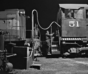 Tennessee Central Railway hostler uses flashlight to see fuel gauge on Alco switcher in June 1962. Photograph by J. Parker Lamb, © 2016, Center for Railroad Photography and Art. Lamb-02-024-06