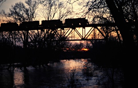 Northbound Detroit, Toledo and Ironton Railroad freight train crossing Great Miami River in Quincy, Ohio, at sunset on March 22, 1980. Photograph by John F. Bjorklund, © 2016, Center for Railroad Photography and Art. Bjorklund-52-19-01