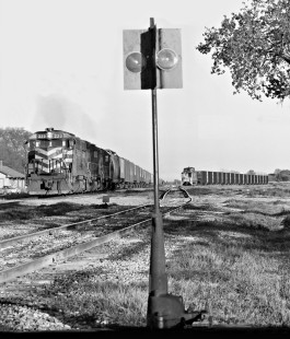 Northbound Missouri–Kansas–Texas Railroad grain train empties depart yard in Smithville, Texas, as coal train awaits crew in March 1989. Photograph by J. Parker Lamb, © 2016, Center for Railroad Photography and Art. Lamb-02-076-07