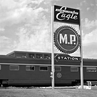 Northbound Missouri Pacific Railroad <i>Texas Eagle</i> passenger train arrives at Austin, Texas, in June 1962. Sign faces major street beneath train. Photograph by J. Parker Lamb, © 2016, Center for Railroad Photography and Art. Lamb-02-058-08