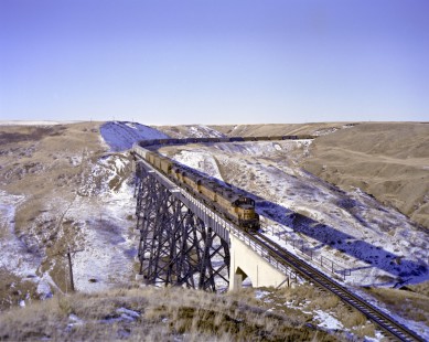 Milwaukee Road diesel locomotive no. 556 crosses Red Coulee trestle bridge near Salem, Montana, with eastbound freight from Great Falls on February 24, 1980. Photograph by Victor Hand. Hand-MILW-C67-22