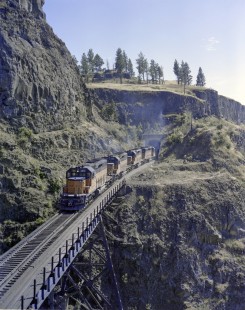 Milwaukee Road diesel locomotive no. 134 leads eastbound freight train at Tunnel no. 44 at the edge of Rock Lake in Washington on June 18, 1978. Photograph by Victor Hand.   Hand-MILW-C67-07