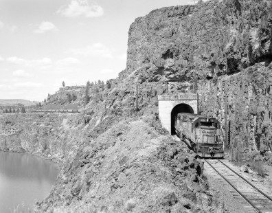 Milwaukee Road diesel locomotive no. 135 hauls westbound grain train through tunnel on the edge of Rock Lake in Washing on June 17, 1978. Photograph by Victor Hand. Hand-MILW-67-078