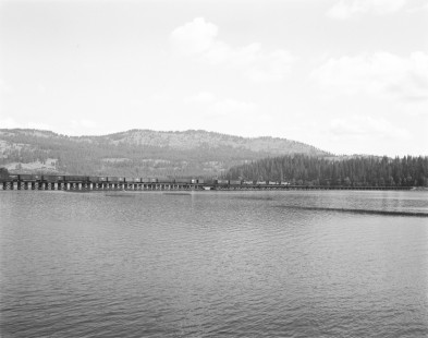 Milwaukee Road diesel locomotive no. 23 hauls eastbound freight across trestle bridge over Lake Benawah near Ramsdell, Idaho, on June 16, 1978. Photograph by Victor Hand. Hand-MILW-67-067