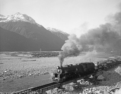 New Zealand Government Railways steam locomotive no. 1216 hauls freight near Aickens on the South Island of New Zealand on June 9, 1967. Photograph by Victor Hand. Hand-NZGR-12-0976.