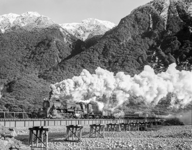 New Zealand Government Railways steam locomotive no. 1242 crosses the over the Waimakariri River with eastbound freight near Arthur's Pass on the South Island of New Zealand on July 21, 1966; Photograph by Victor Hand; Hand-NZGR-10-757.