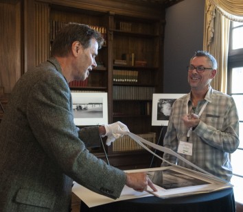 Jeff Brouws and Eric Williams prepare Eric's photography exhibition for the Friday night reception. CRP&A Conversations 2019 photograph by Henry A. Koshollek