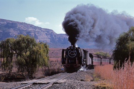 South African Railways 25NC-class steam locomotive no. 3419 leads a southbound passenger train at location know as Generaalsnec in South Africa, on May 30, 1985. Photograph by Katherine Botkin. BOTKINK-113-KT-89, © 1985, Katherine Botkin.