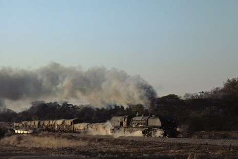 National Railways of Zimbabwe 15th-class Garratt steam locomotive no. 410 leads northbound freight train at Deka, Hwange District, Matabeleland North, Zimbabwe, on July 11, 1990. Photograph by Katherine Botkin. BOTKINK-114-KT-39, © 1990, Katherine Botkin.