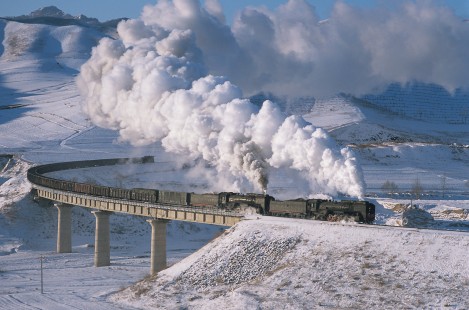 Jitong Railway QJ-class steam locomotives lead eastbound freight over the Er-Di Viaduct east of Hadashan, Inner Mongolia, China, on November 26, 2003. Photograph by Willian Botkin. © 2001, William Botkin