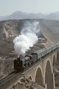 Chinese National Railway QJ-class steam locomotive no. 711 leads eastbound passenger train over the Yellow River at Qingbaishi, Gansu, China, on April 14, 1988. Photograph by Katherine Botkin. BOTKINK-103-KT-68, © 1988, Katherine Botkin.
