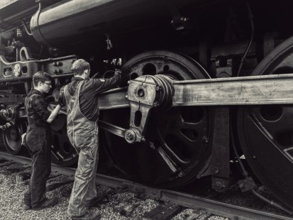Two volunteers grease the bearings of the Milwaukee Road 261 before an excursion the following morning, in June 2019. © Charlie Voyda