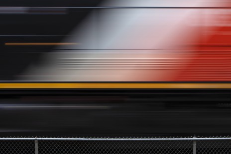 A slow shutter speed blurs the graphics on the lead locomotive of a passing westbound CN train at Brampton, Ontario, Canada, on May 11, 2019. © Ron Bouwhuis