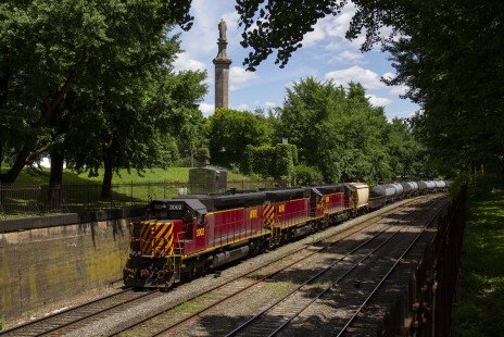 Three Allegheny Valley SD40-3s bring their daily interchange job through Allegheny Commons Park in Pittsburgh, Pennsylvania on its way to Norfolk Southern's Island Avenue Yard, on June 22, 2019. Behind the train is the park's Civil War monument. © Jerry Jordak