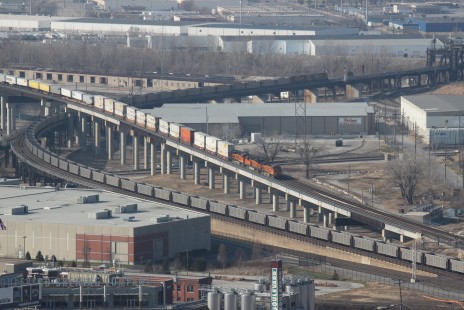 An unidentified eastbound BNSF container train arrives Kansas City on the Argentine flyover while an unidentified westbound Union Pacific train of empty aluminum hopper cars negotiates the Highline underneath to cross over the Kansas River into Kansas on a chilly December day. Both trains are shown are actually seen in both Missouri and Kansas simultaneously - the triple crossing at Santa Fe Junction straddles the state line. © Ralcon Wagner