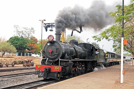 Railway Station at Victoria Falls in Zimbabwe, on November 10, 2019. The tourist dinner train runs down to Victoria Falls Bridge and then backtracks about ten miles to Jafuta Siding. The engine is Zambian Railways No. 204 (formerly Rhodesian Railways), a 12th Class 4-8-2 built in Scotland by North British Locomotive Co. © Alan Furler