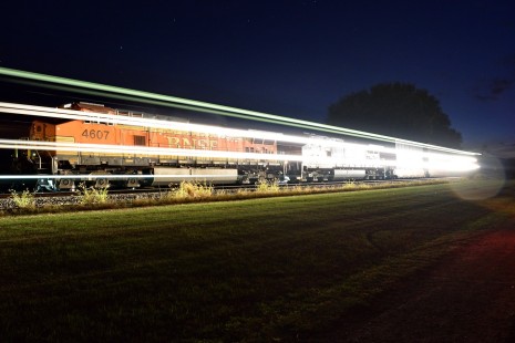 The crew of a stopped BNSF train in Shabbona, Illinois begins to shut down their train for the night as another eastbound passes during a summer night in 2018. © Jeff Wojo