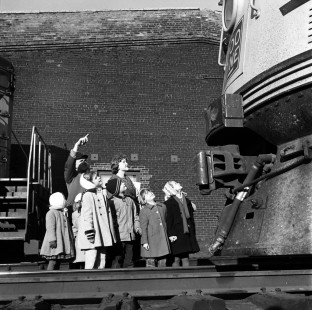 A group of children on a school tour from Hopkins, Minnesota gaze up in awe at a Soo Line Railroad diesel locomotive at the Shoreham Shops in Minneapolis, in November 1959. Photograph by Wallace Abbey. © 2020, Center for Railroad Photography and Art, Abbey-04-129-04