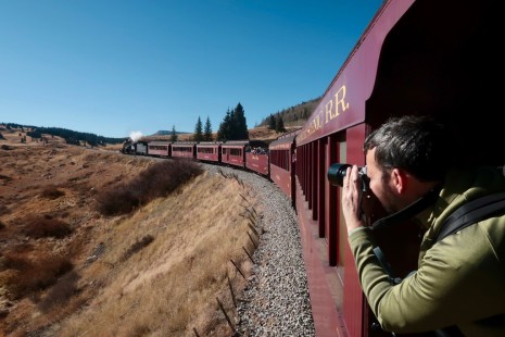 Scott Lothes, president and executive director of the Center for Railroad Photography & Art, never loses his excitement for railroading. Onboard the Lexington Group charter train on the Cumbres & Toltec Scenic Railroad (C&TSR), Lothes captures a shot of the locomotive hugging a curve just east of the Los Piños water tank in Chama, New Mexico, on October 26, 2019. © Bill Schafer