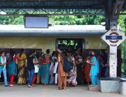 An interurban train has just arrived at Dadar Station, where many trains offer women only cars. This image captures the beautiful collage of color and textures of local dress boarding the train in Mumbai, India, in 2011. © Todd Halamka