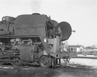 A worker cleans the smokebox of French National Railways  steam locomotive no. 141-R 1218 at Nevers, Nièvre, France, on January 12, 1968. Photograph by Victor Hand, Hand-SNCF-14-150