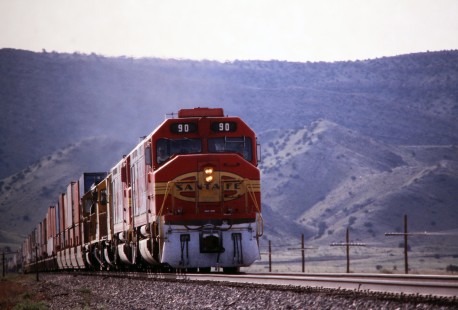 Westbound Atchison, Topeka and Santa Fe Railway stack train exits Abo Canyon at Sais siding south of Albuquerque, New Mexico, in July of 1991. Photograph by J. Parker Lamb. Lamb-03-033-16.JPG; © 2016, Center for Railroad Photography and Art